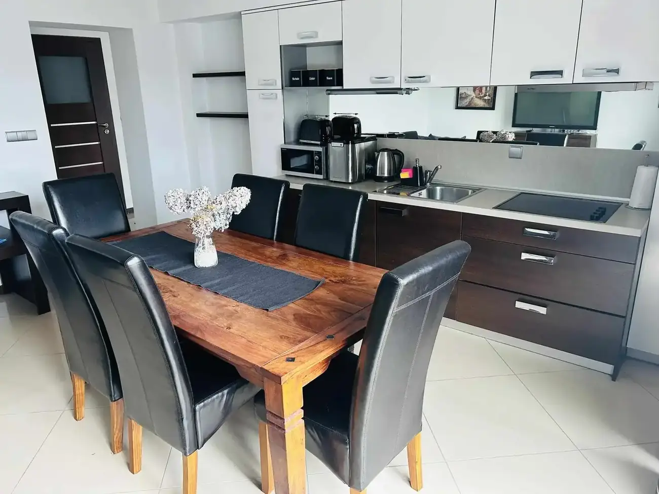 Jadalnia z drewnianym stołem i aneksem kuchennym — Apartament 3, Zatoka Cydrowa w Stegnie